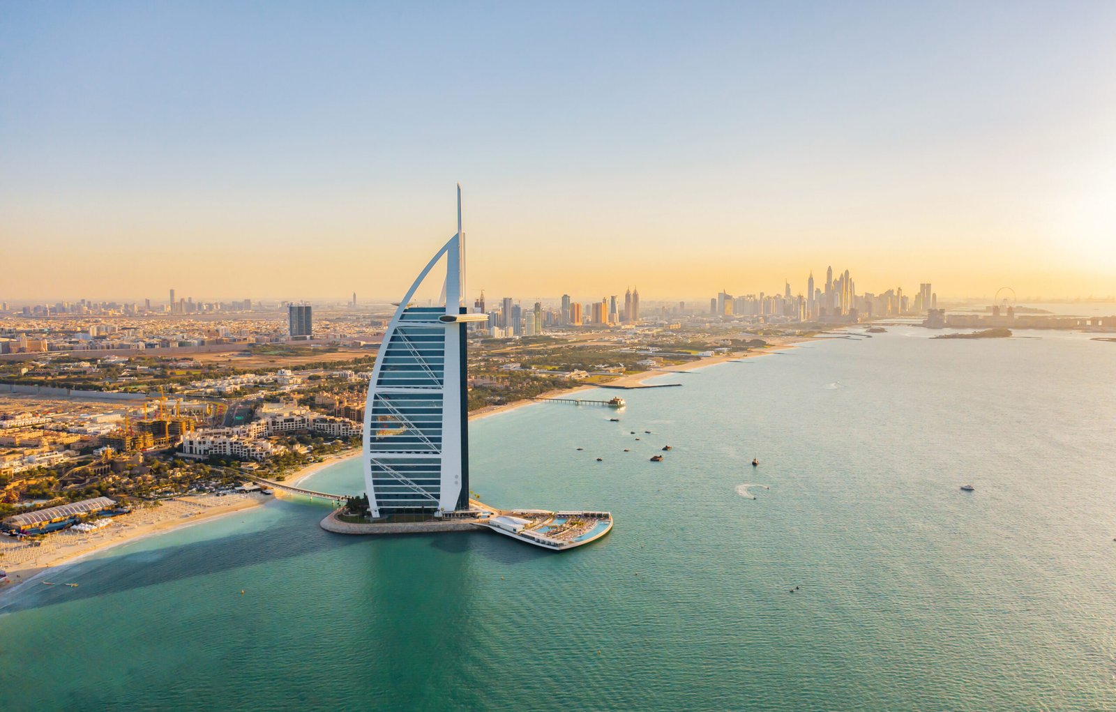 Aerial view of Burj Al Arab Jumeirah Island or boat building, Dubai Downtown skyline, United Arab Emirates or UAE. Financial district in urban city. Skyscrapers at sunset.